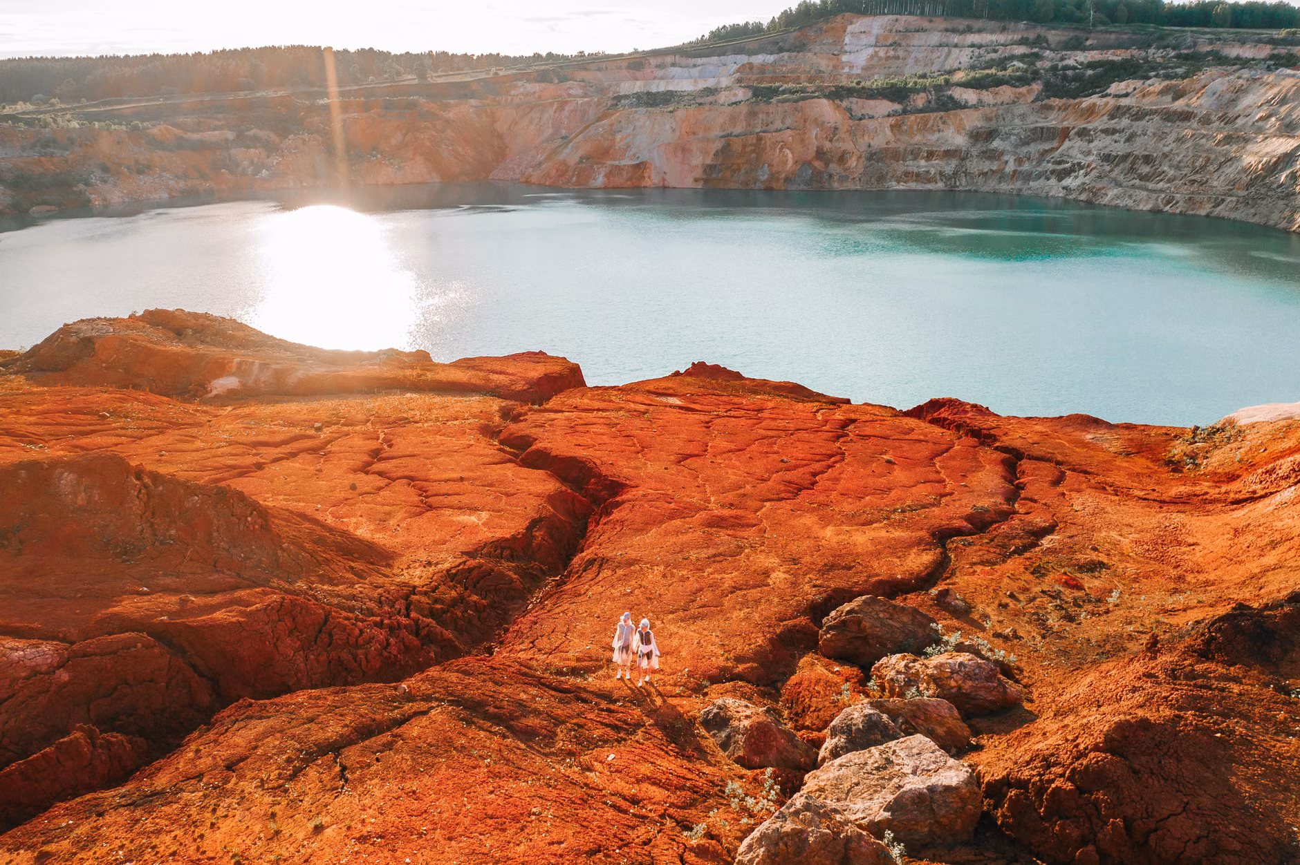 Drone shot capturing a vibrant quarry lake and rocky terrain in Guryevsky District, Russia.