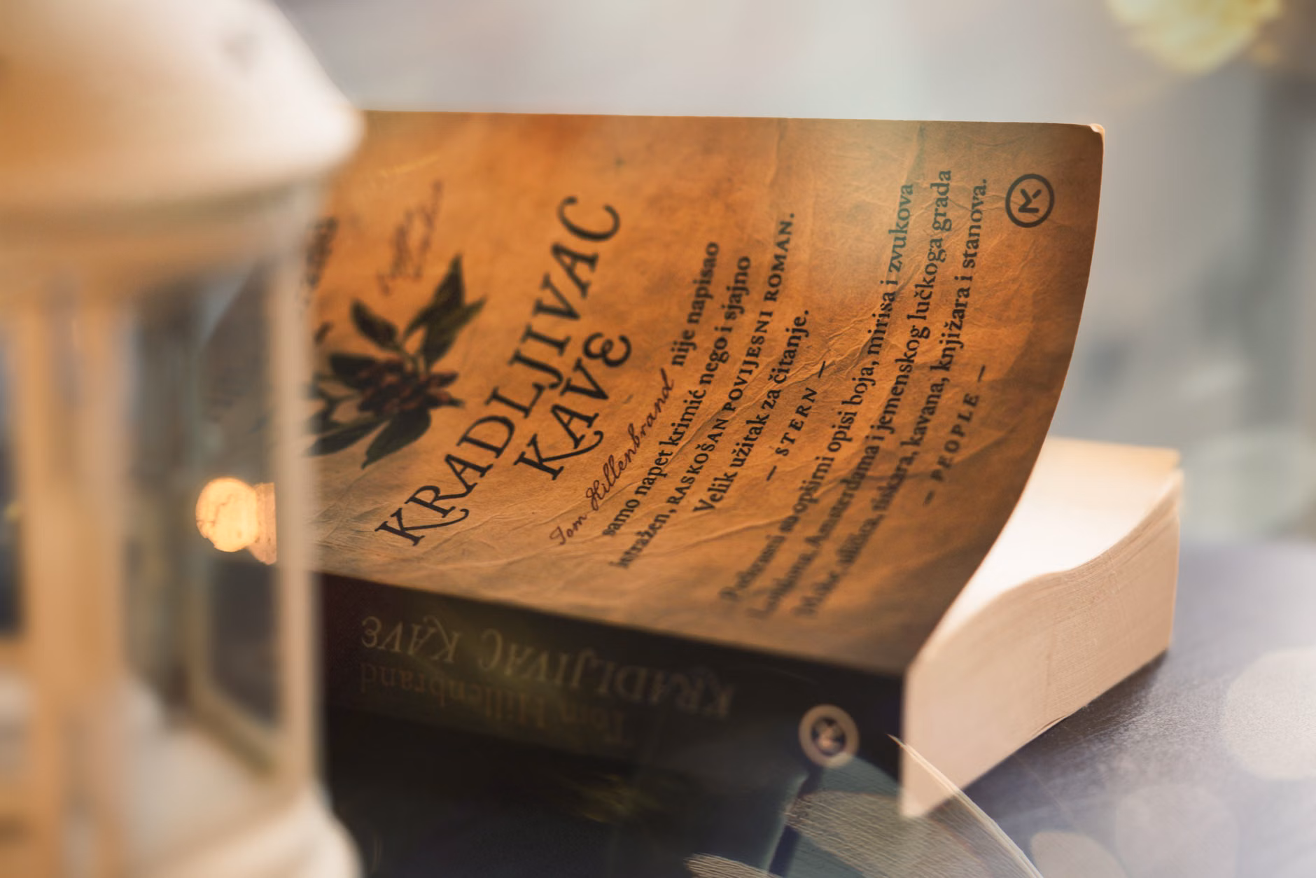 Close-up of a vintage book page with warm light and lantern ambiance.