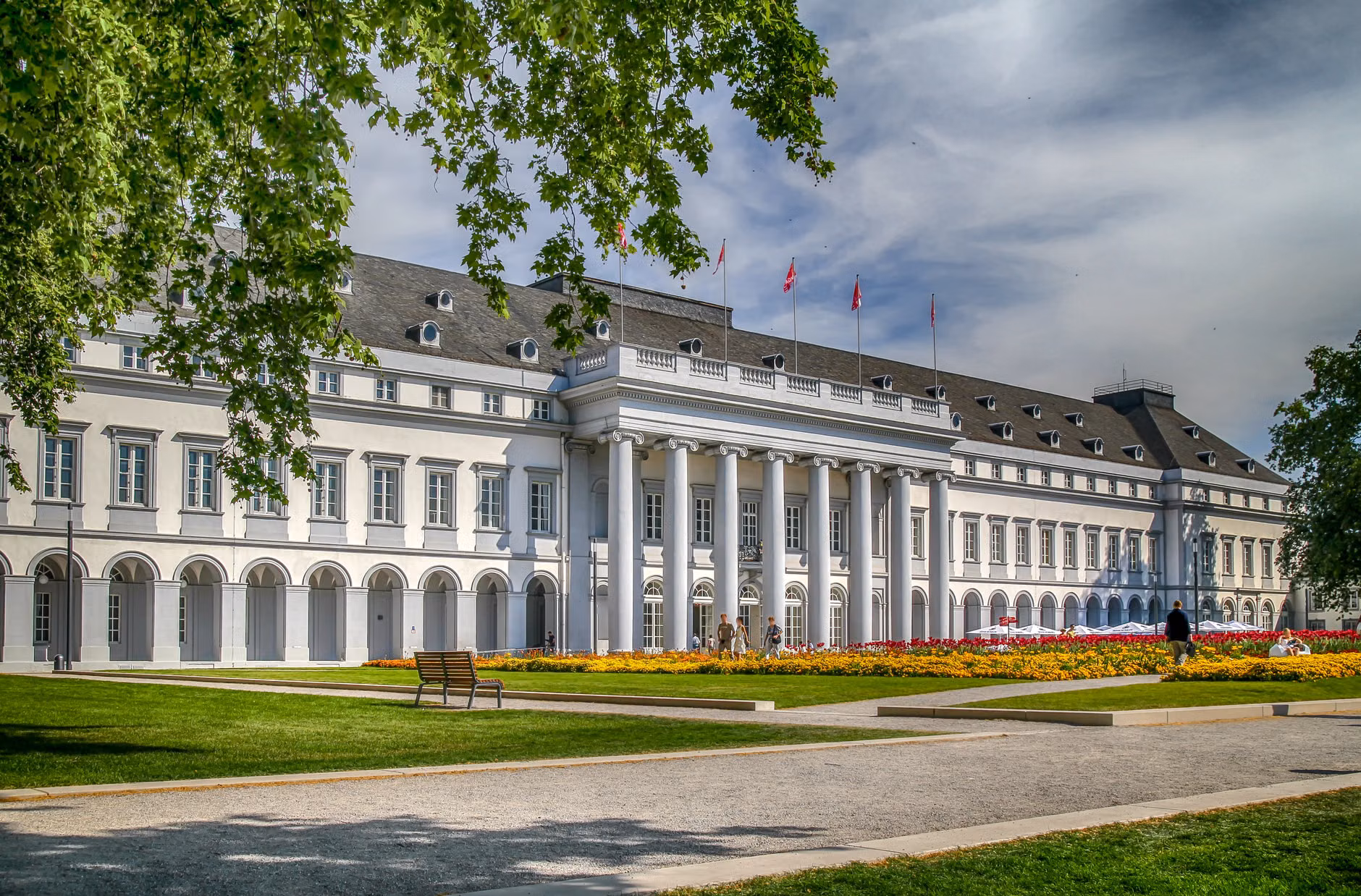 Der majestätische Wahlpalast in Koblenz, umgeben von Gärten und lebendiger grüner Vegetation.