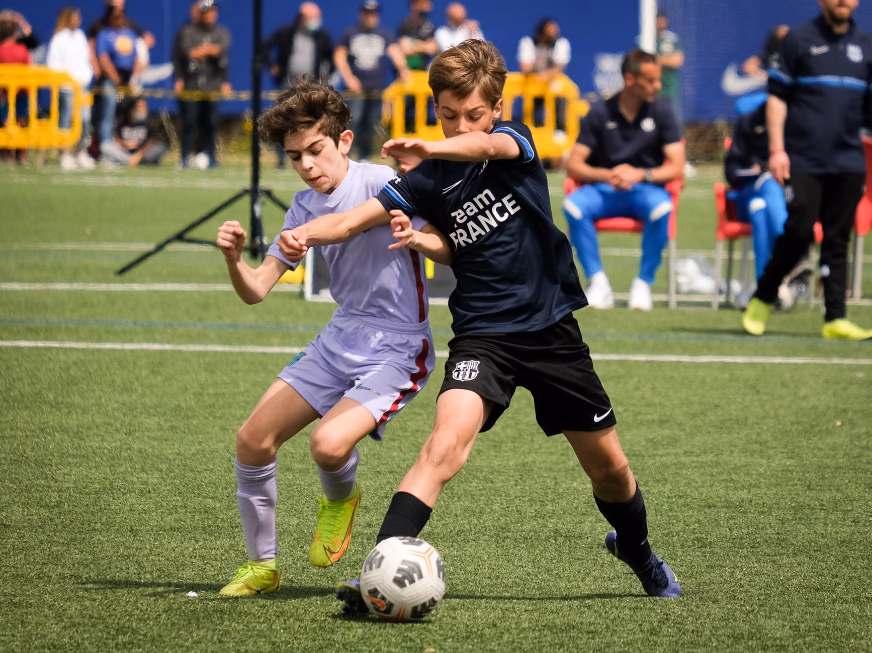De jeunes athlètes s'affrontent dans un match de football dynamique à Barcelone, en Italie, mettant en avant le travail d'équipe et le fair-play.