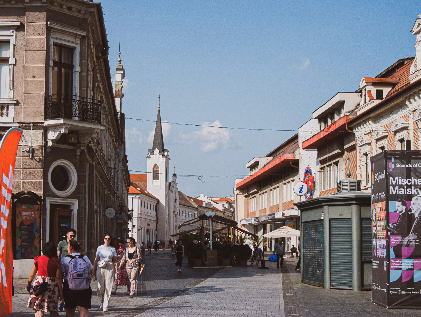 Street view featuring historical architecture and people in a European city, capturing a lively urban atmosphere.