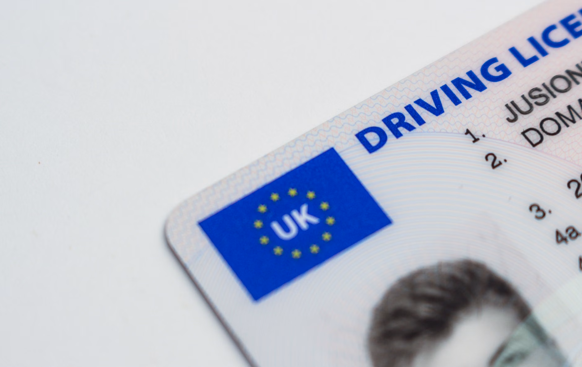 Photo détaillée d'un permis de conduire britannique montrant le drapeau de l'UE et les caractéristiques d'identité.