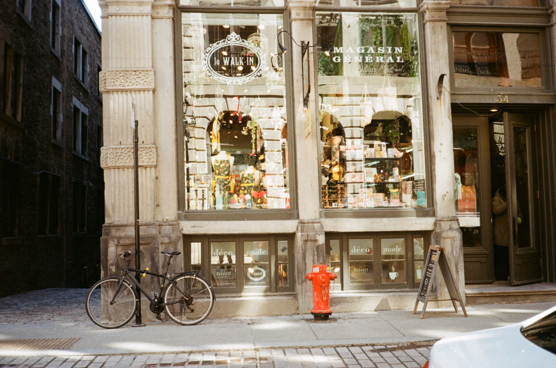 Photo de style vintage d'une devanture de boutique avec vélo et rue pavée.